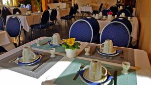 uma sala de jantar com uma mesa com pratos e guardanapos em Pension ZUM LINDENWALD Colbitz em Colbitz