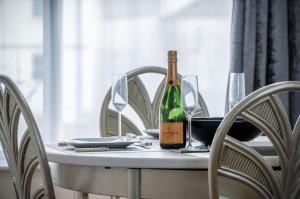 a bottle of wine sitting on a table with glasses at Fulke Street - 2 Bedroom Apartment - Milford Haven in Milford Haven