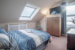 a bedroom with a bed and a tv and a window at Fulke Street - 2 Bedroom Apartment - Milford Haven in Milford Haven