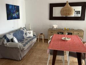 a living room with a table and a couch at Apartamento con preciosa vista al mar y AA in Son Parc
