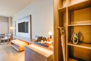 a hotel room with a bedroom with a couch and a television at DoubleTree by Hilton Porto Alegre in Porto Alegre