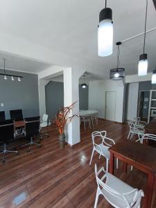 um quarto vazio com cadeiras brancas, uma mesa e secretárias em Hotel Interlagos em San Juan