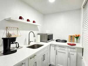 a white kitchen with a sink and a microwave at Getaway / Privacy Suite B in Lutz