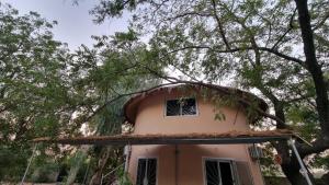 een huis met een rieten dak onder een boom bij Les Fromagers in Missira