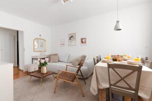 ein Wohnzimmer mit einem weißen Sofa und einem Tisch in der Unterkunft 7Heaven Dream - City Center in Warschau