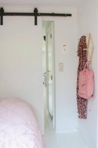a bedroom with a bed and a pink bag at Boshuisje op de Veluwe met sfeervolle tuinkas in Putten