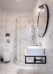 a bathroom with a shower and a sink and a mirror at Dwór Konstancin in Konstancin-Jeziorna