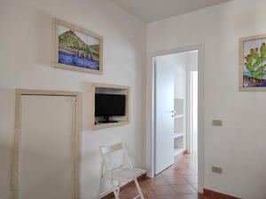 a white room with a chair and a television at Case per Vacanze Praia in Favignana