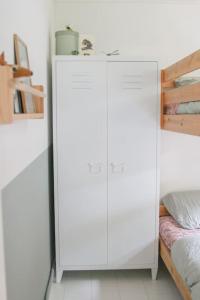 a bedroom with a white cabinet next to a bed at Boshuisje op de Veluwe met sfeervolle tuinkas in Putten