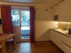 a kitchen with a large window and a table at Sauze Apartment in Sauze dʼOulx