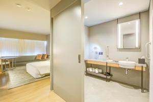 a bathroom with a sink and a bed in a room at DoubleTree by Hilton Porto Alegre in Porto Alegre