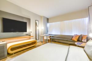 a hotel room with a couch and a flat screen tv at DoubleTree by Hilton Porto Alegre in Porto Alegre