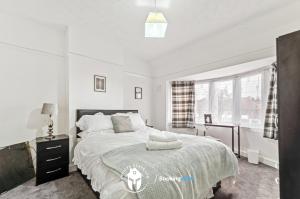 Un dormitorio blanco con una cama grande y una ventana en 3 Bedroom House By Invicta Stays Short Lets Near City Centre Leicester With Free Wi-Fi Free Parking en Leicester