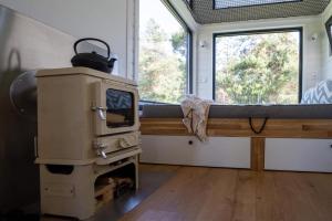a room with a stove and a window at Heaven Reset & Spa - Domek przy lesie in Korczew