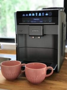 two cups sitting next to a toaster oven at Heaven Reset & Spa - Domek przy lesie in Korczew