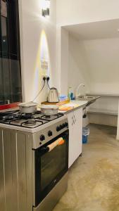 a kitchen with a stove with a pot on it at Fairline Gardens Hiriketiya in Dickwella