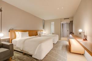 two beds in a hotel room with a couch at DoubleTree by Hilton Porto Alegre in Porto Alegre