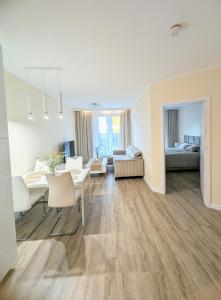 a white living room with a table and a couch at Apartament Leomar, bezkontaktowe zameldowanie, darmowy parking in Poznań