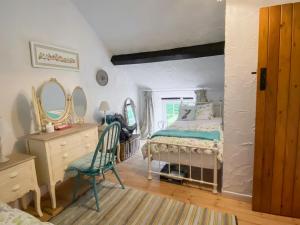 a bedroom with a bed and a dresser and mirror at Swallow Cottage - A Cosy Retreat Near Snowdonia and the Coast in Abergele