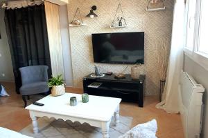 a living room with a tv and a coffee table at Les Oliviers : Studio spacieux belle vue mer, Clim in Port-Vendres