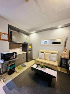 ein Wohnzimmer mit einem Sofa und einem Tisch in der Unterkunft Yulee’s Comfortable Home Seakyung Village condo in Lapu Lapu City