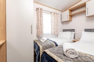 a bedroom with two beds and a window at Lodge 13 The Silverdale Close to St Andrews in Strathkinness