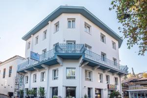 een wit gebouw met een balkon bij Eliada Hotel in Kuşadası