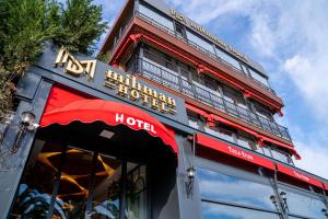 a building with a hotel sign on top of it at Mihman Hotel in Tuzla