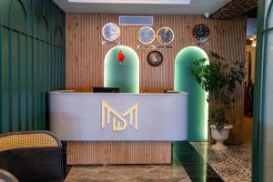a lobby with a counter with themn logo on it at Mihman Hotel in Tuzla