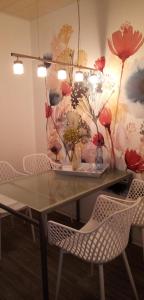 uma mesa de jantar com cadeiras e flores na parede em Fewo Summertime em Hehlen