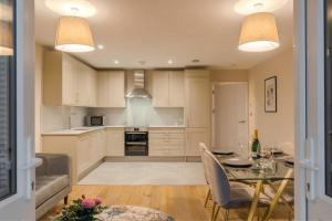 a kitchen and dining room with a table and chairs at Escape in Style to Windsor with Free Parking in Windsor