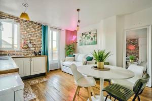 a kitchen and a living room with a table and chairs at Fabuleux Paris/ Stade de france in Saint-Denis