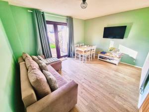 a living room with a couch and a flat screen tv at Bluebirds Cottage - Light & Airy 2 Bed in Bourton! in Bourton on the Water