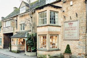 an old brick building with a restaurant on a street at Bluebirds Cottage - Light & Airy 2 Bed in Bourton! in Bourton on the Water