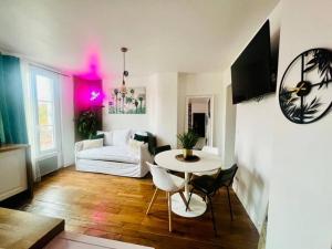 a living room with a table and a couch at Fabuleux Paris/ Stade de france in Saint-Denis