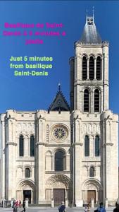 a large building with a tower with a clock on it at Fabuleux Paris/ Stade de france in Saint-Denis