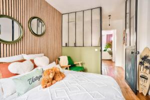 a teddy bear sitting on a bed in a bedroom at Fabuleux Paris/ Stade de france in Saint-Denis