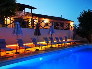 uma piscina com cadeiras e guarda-sóis ao lado de um edifício em Italian Experience- Villa BellaLuce 18 em Loreto