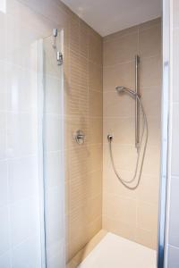 a shower stall in a bathroom with beige tiles at Hotel La Baia in Cochem