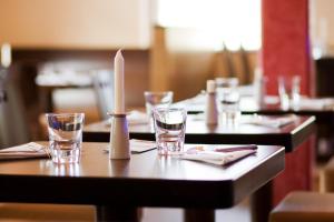 a table with glasses and a candle on it at Hotel La Baia in Cochem