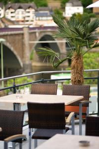 a table and chairs with a palm tree in the background at Hotel La Baia in Cochem