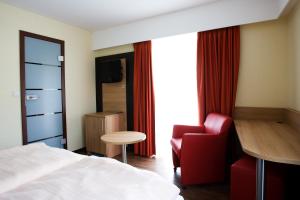a hotel room with a bed and a chair and a table at Hotel La Baia in Cochem