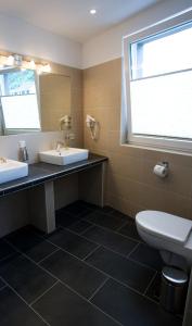a bathroom with two sinks and a toilet and a window at Hotel La Baia in Cochem