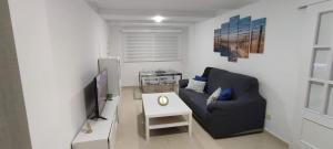a living room with a couch and a tv at Sunlivetenerife in Candelaria