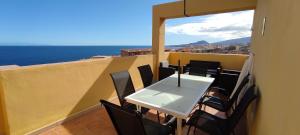 a table and chairs on a balcony with a view of the ocean at Sunlivetenerife in Candelaria