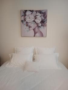 a picture of a woman with flowers above a bed at Domaine de Pladuc in Lachaise