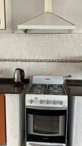 - une cuisine équipée de plaques de cuisson blanches dans l'établissement Casa vista panorámica al lago, à Córdoba