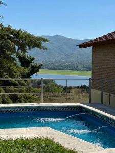 - une piscine en face d'une maison avec vue dans l'établissement Casa vista panorámica al lago, à Córdoba