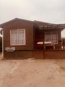 een klein houten huis met 2 ramen en een veranda bij Cabaña colmo in Quintero