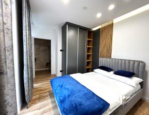 1 dormitorio con 1 cama grande con sábanas azules en Panorama Zamkowe 6, en Rzeszów
